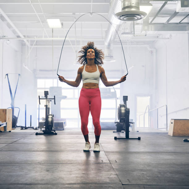 A woman working out alone in a cross training gym.