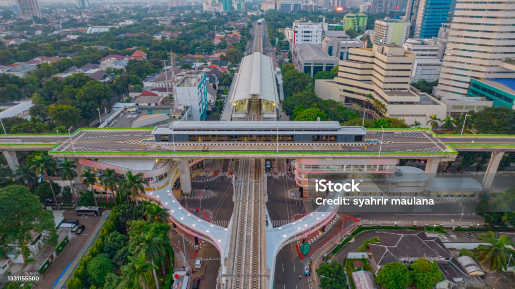 Aerial view of articulated city buses arriving and leaving at bus station near main railway station Aerial view of articulated city buses arriving and leaving at bus station near main railway station MRT line at Kebayoran Baru. Jakarta, Indonesia Jakarta Stock Photo