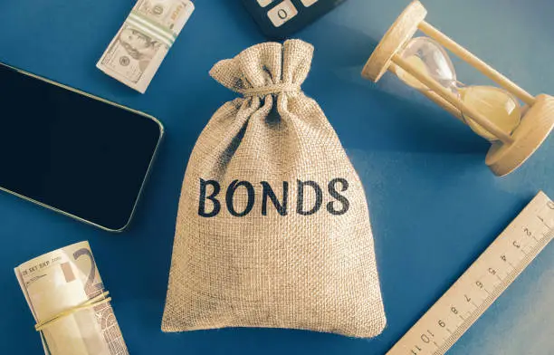 Photo of Money bag with the word Bonds. A bond is a security that indicates that the investor has provided a loan to the issuer. Equivalent loan. Unsecured and secured bonds.