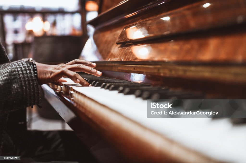 African Male Gently Playing The Piano Piano Stock Photo