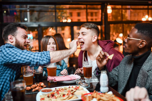 amigos homens se alimentando enquanto desfrutam de festa de pizza - city chicken - fotografias e filmes do acervo