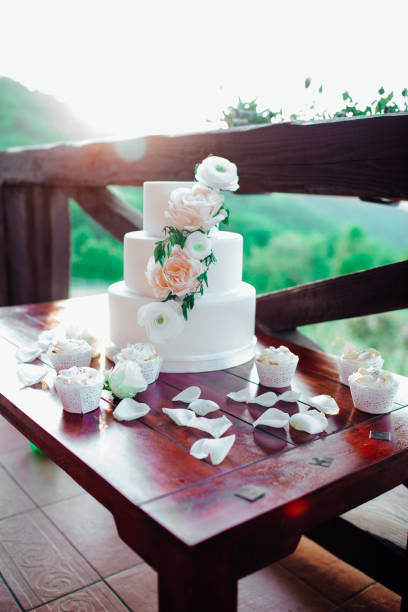 istock White wedding cake with flowers on a wooden table. 1331160270