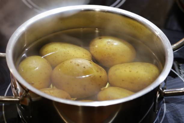 istock potatoes cooking on a steel pot, steam 1331160301