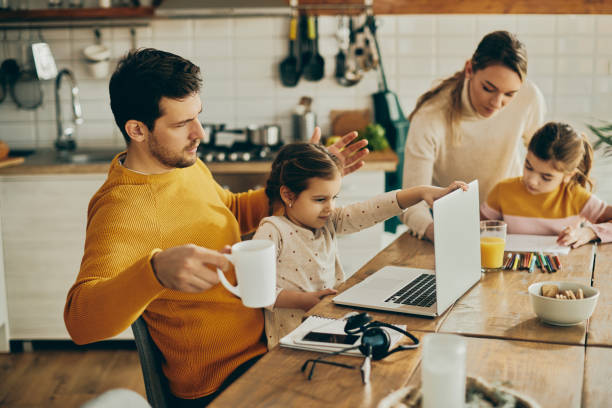 istock Small girl using father's laptop while he's working at home. 1331161484