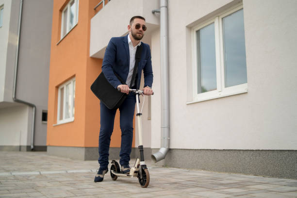 istock Happy hipster with drink riding scooter 1331162494