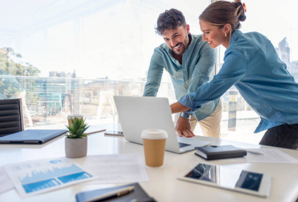 biznesmen i bizneswoman pracuje na laptopie - couple laptop computer digital tablet zdjęcia i obrazy z banku zdjęć