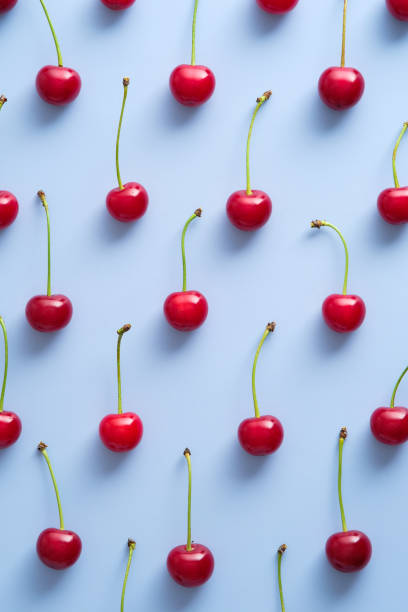 istock Cherry pattern. Flat lay of cherry berries on blue background. Top view 1331166587