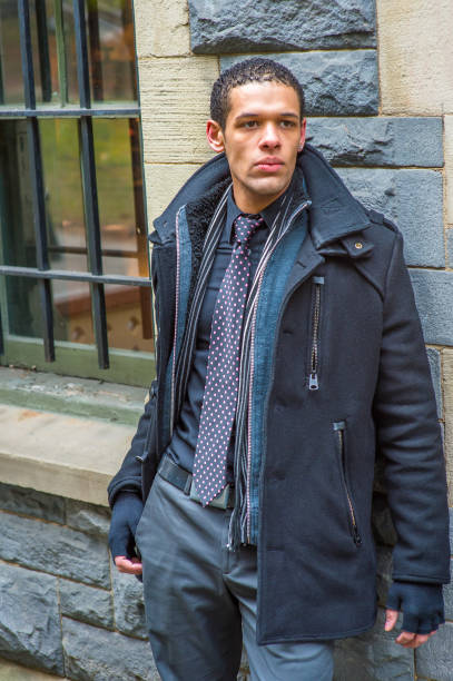 istock Young man standing outdoors against wall in winter, looking forward 1331171079