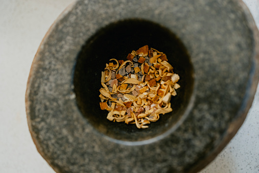 A close up, high angle shot of a mortar containing spices ready for grinding