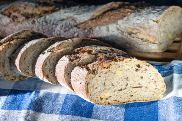 istock Freshly prepared grain bread slices on a kitchen towel. Various nuts in self made home bread. Closeup 1331172295