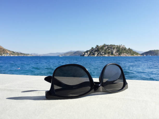 istock Sunglasses on the table with sea background 1331172531