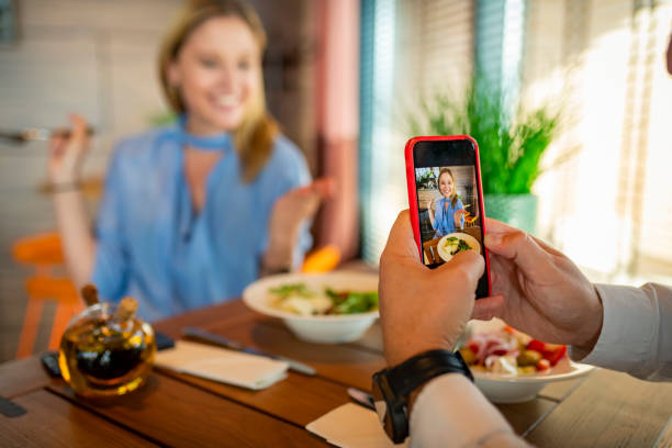 istock Romantic Young Couple is Taking a Photography While Having a Lunch Break in the Restaurant and Enjoying Delicious Food. 1331179369