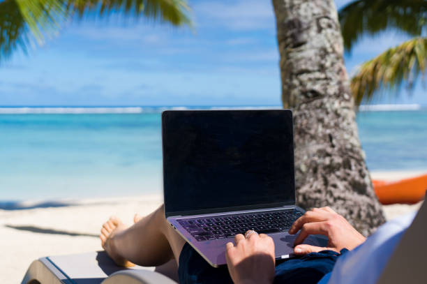istock Woman using laptop on a beach, remote working 1331188397