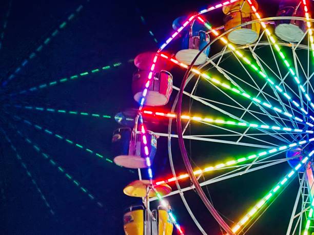 vivid vibrant multicolored lights of ferris wheel at - kermis stockfoto's en -beelden