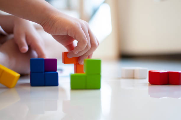 istock Child plays with wooden blocks on the floor. 1331205830