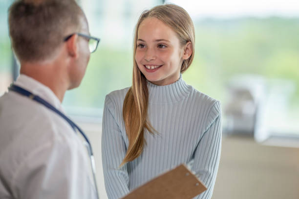 istock Elementary aged girl visits the doctor 1331206800
