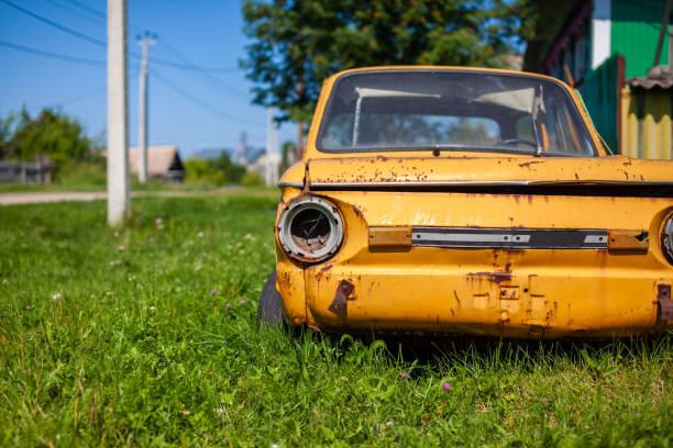 Old yellow wrecked car in vintage style. Abandoned rusty yellow car. Old yellow wrecked car in vintage style. Abandoned rusty yellow car. Close-up of the headlights of the front view of a rusty, broken, abandoned car near the house. Concept of abandoned used car. distressed rusty vintage pickup truck close up detail stock pictures, royalty-free photos & images