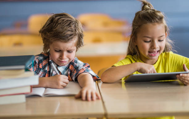 istock New vs. old way of studying at elementary school! 1331216320
