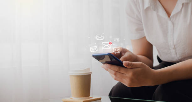 istock Young woman holding smart phone sending electronic message and checking email online on web with technology concept with box icon. 1331218257