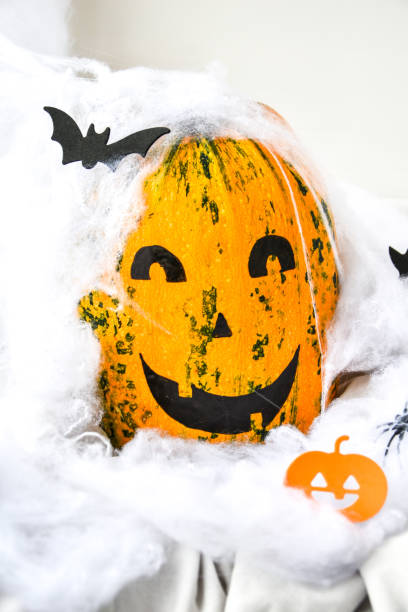 тыква с нарисованным лицом на цветном фоне к хэллоуину. паутина. праздничные украшения - jack fruit стоковые фото и изображения
