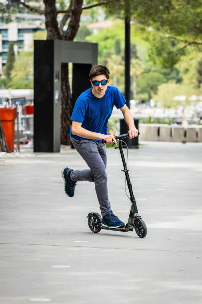 istock Teenager riding push scooter 1331222611