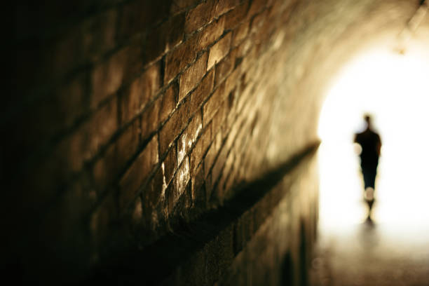 istock Silhouette of a people going through a brick tunnel 1331226305