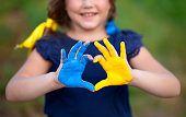 Liebe Ukraine Konzept. Kleines Mädchen zeigt Hände in Herzform in ukrainischer Flaggenfarbe - gelb und blau. Unabhängigkeitstag der Ukraine, Flagge, Verfassungstag Bildung, Schule, Kunstunterricht Konzept