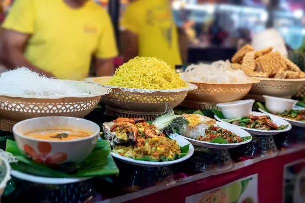 thai food at the market in Phuket. noodles, tom yam soup, salads and traditional street food of Thailand on display.