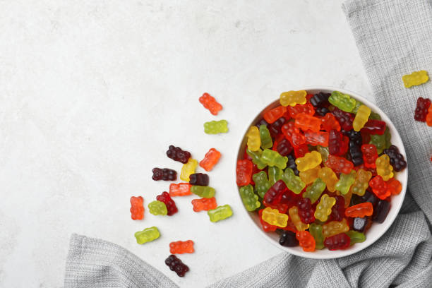 istock Delicious gummy bear candies on light table, flat lay. Space for text 1331240984