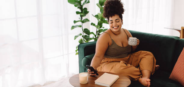 istock Healthy woman with coffee using cell phone at home 1331242351
