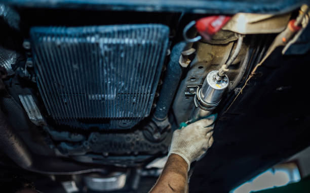 Replacing the fuel filter of a diesel car in a car service, dismantling the fuel filter under the bottom of the car. stock photo
