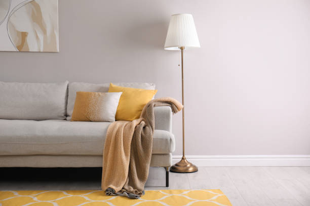 istock Comfortable sofa with cushions and plaid in stylish living room, space for text. Interior design 1331244236