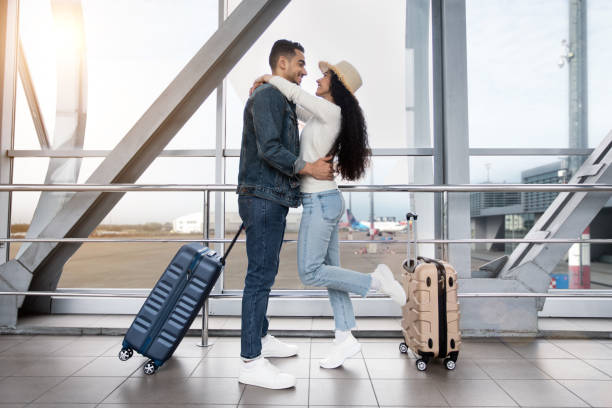 공항 터미널에서 비행기를 기다리는 동안 포옹하는 낭만적 인 아랍 커플 - honeymoon airplane window travel 뉴스 사진 이미지