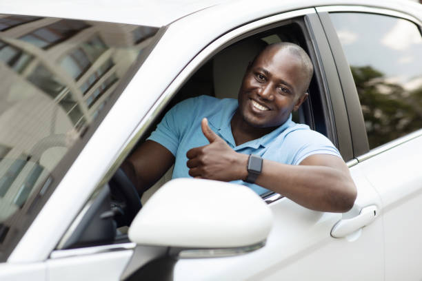 istock Handsome black man driving car, showing thumb up 1331245166