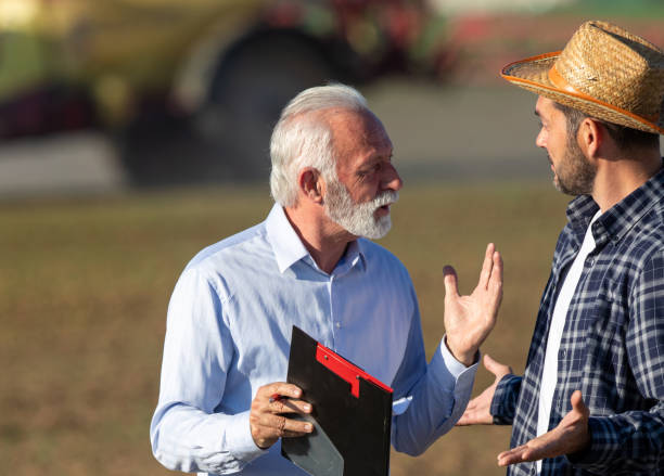 istock Farmer and insurance agent talking in agricultural field in spring 1331245317