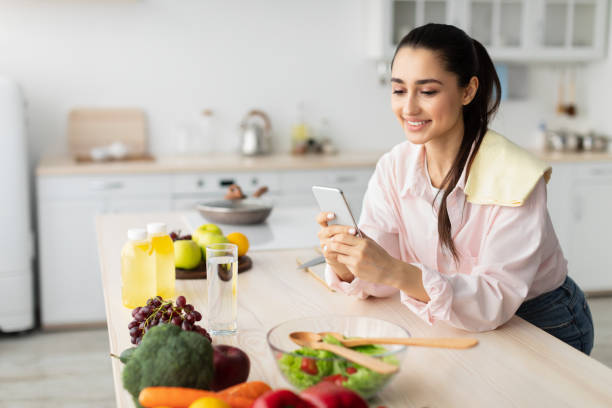 istock Portrait of young housewife using cellphone leaning on kitchen table 1331245637