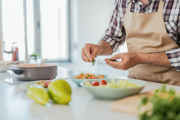 nutrizionista che cucina a casa e prepara insalata - mediterranean diet foto e immagini stock
