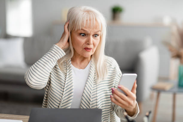 istock Shocked senior woman using her mobile phone 1331245985