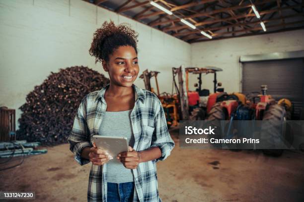 Mixed Race Female Standing In Farm Store Room Organising Layout Using Digital Tablet Stock Photo - Download Image Now