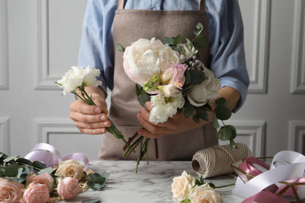 istock Florist creating beautiful bouquet at white marble table, closeup 1331248337