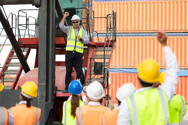 istock warehouse boss engineer standing on crane car with factory workers raise hand for congratulations in containers warehouse storage 1331249381