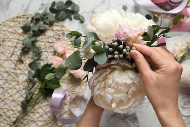 istock Florist creating beautiful bouquet at white marble table, closeup 1331249497