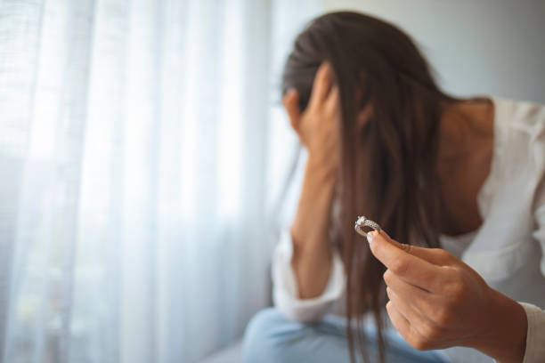 istock Sad heartbroken young woman holding wedding ring 1331249766