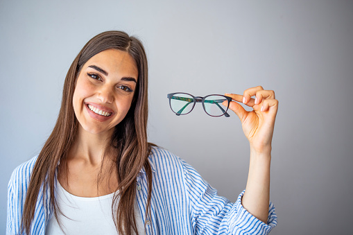 Optician, optometrist, oculist or eye doctor holding glasses and specs with new lenses. Professional eyesight specialist in clinic or shop with spectacles in hand. Bifocal or multifocal eyeglasses.