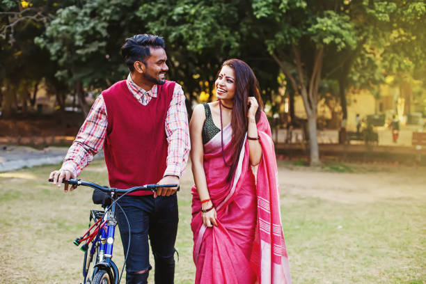 Indian couple with bicycle Young Indian couple in traditional ethnic clothes walking with the bicycle in the park indian man walking in park stock pictures, royalty-free photos & images