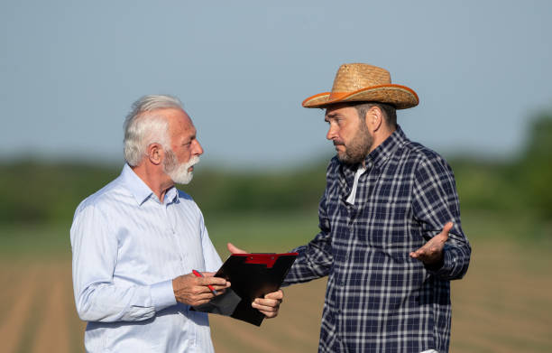 istock Farmer and insurance agent talking in agricultural field in spring 1331250675