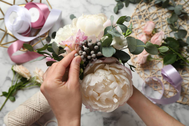 istock Florist creating beautiful bouquet at white marble table, top view 1331250724