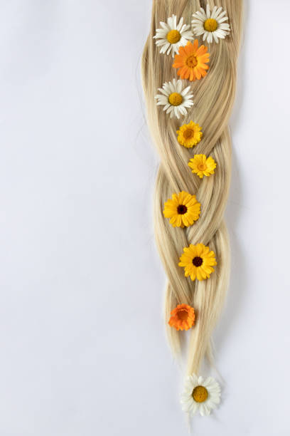 istock Pigtail with chamomile and calendula flowers. Blond hair. 1331254175