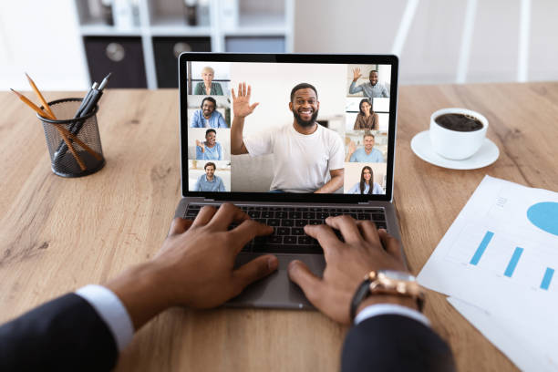 istock Black Businessman Video Conferencing With Colleagues While Sitting At Desk In Office 1331254293