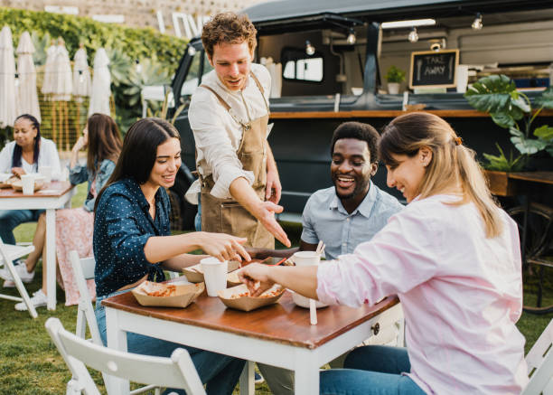 pessoas multirraciais se divertindo comendo em food truck ao ar livre - foco no rosto de menina esquerda - places to go - fotografias e filmes do acervo